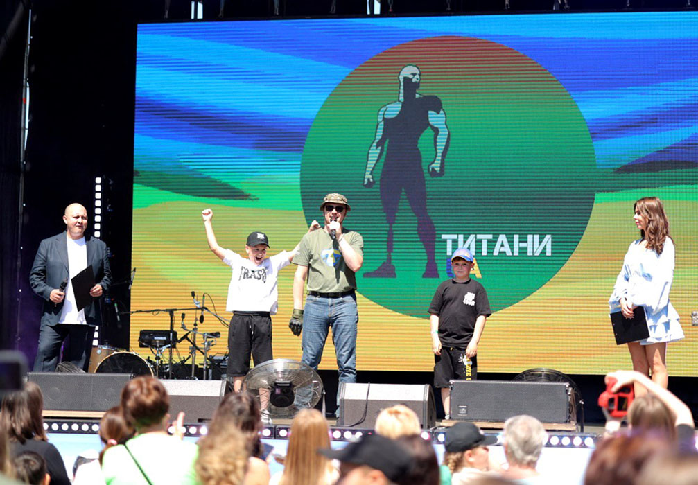 Стас Ралдугін разом із синами Максом і Марком під час вітальної промови з нагоди Дня захисту дітей. ТитаниUA, Дніпро, 2024