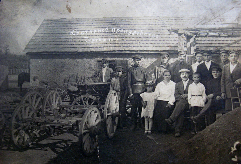 Філат Тертишний з дружиною та дітьми серед робітників кузні, 1920-ті роки. Архів родини Гудімових